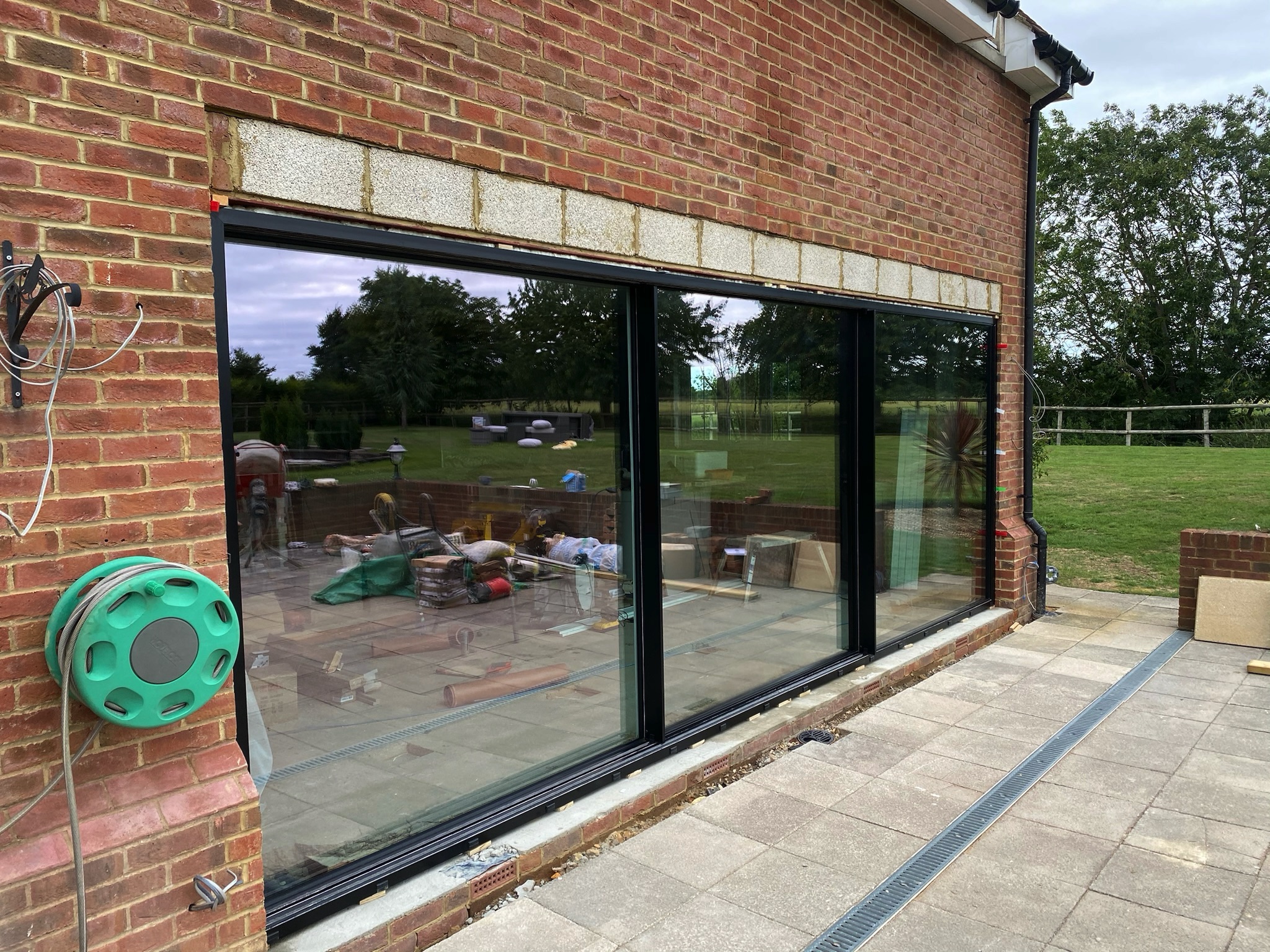 black cortizo sliding doors in a brick extension with stone feature head