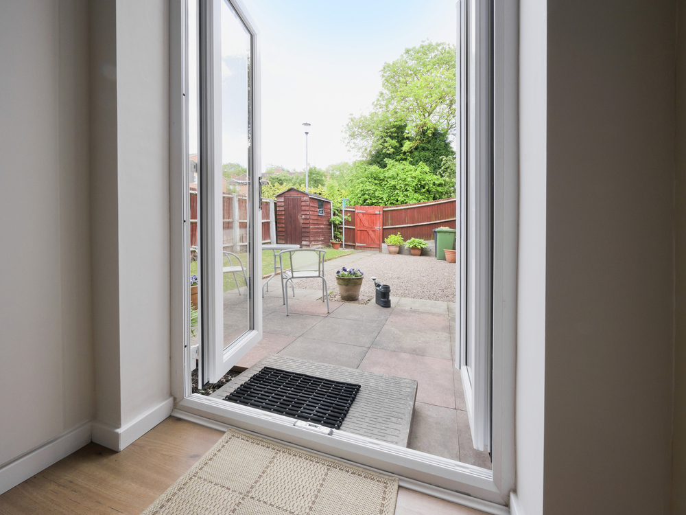 liniar french PVCu doors open leading out to a slabbed patio