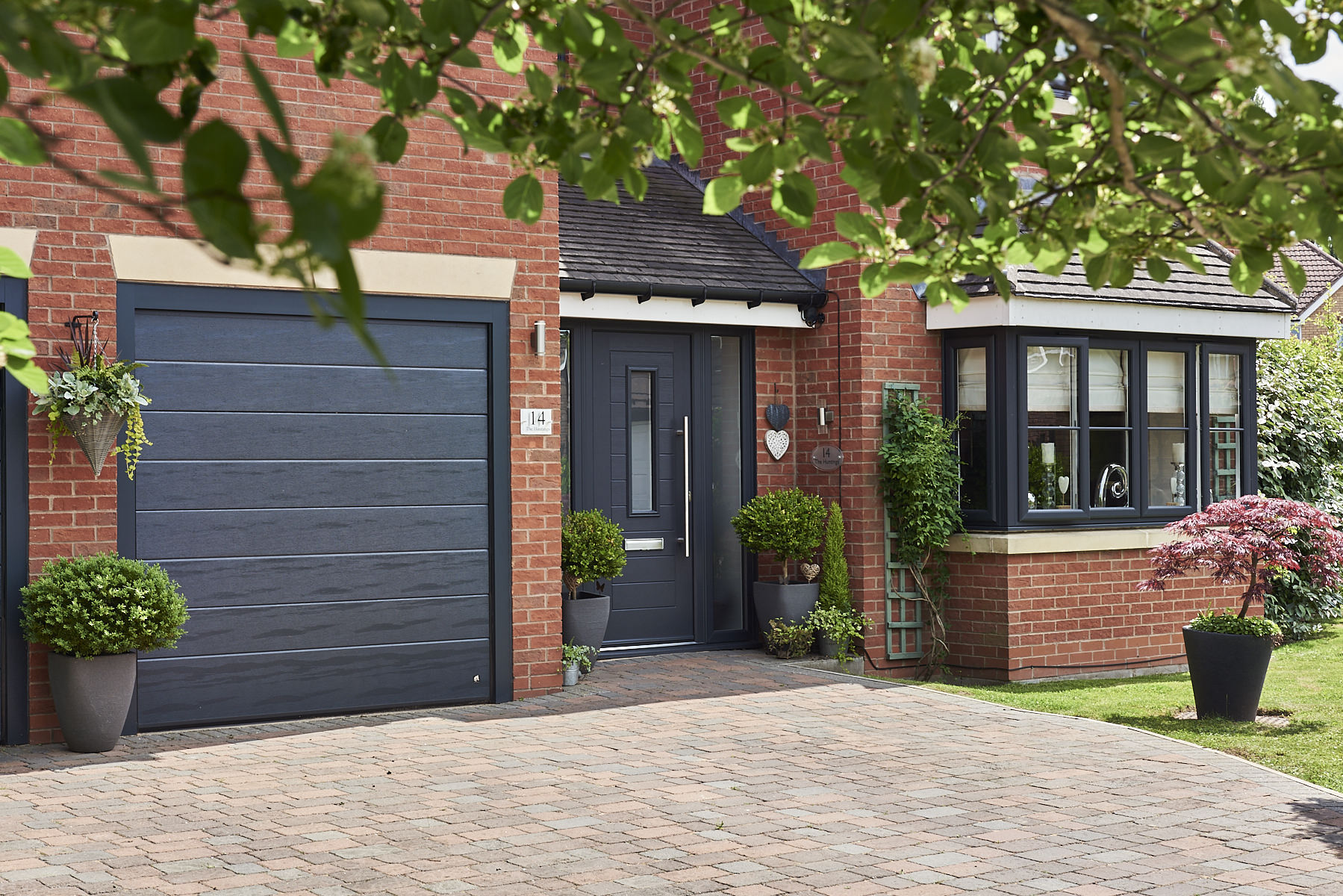 contemporary brick house with grey endurance front door and bay windows