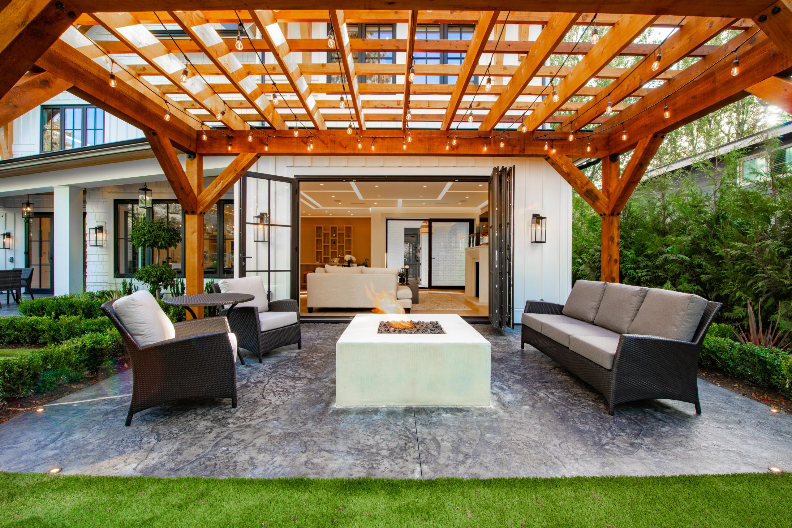 sheerline bifold doors in a patio with timber pergola and open fire