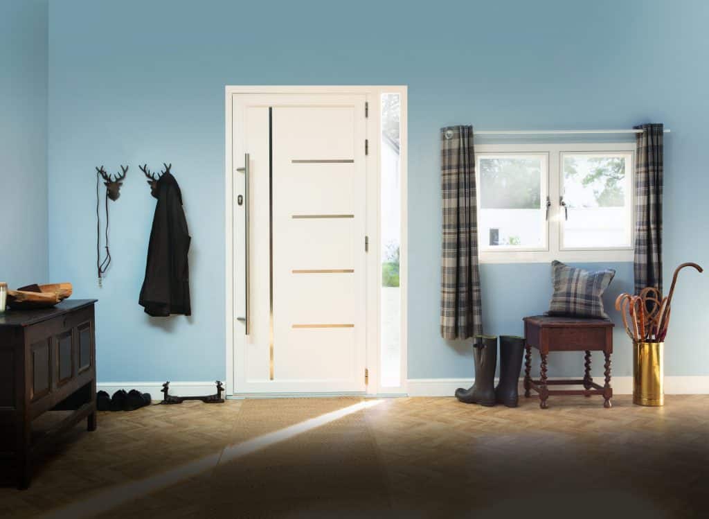 white origin front door with wood floor entrance and matching white window to the side. 