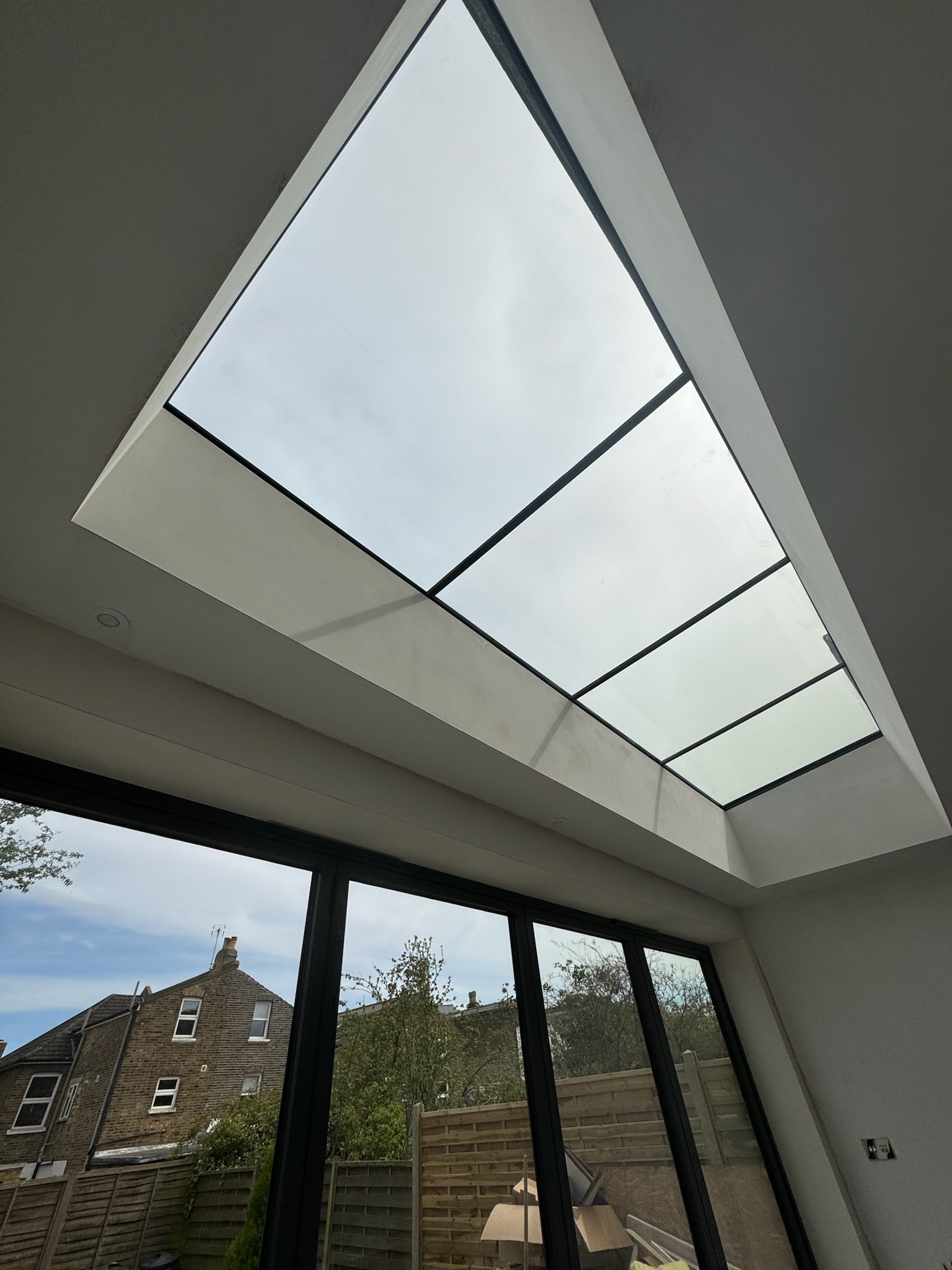 internal view of frameless rooflights above bifold doors. 