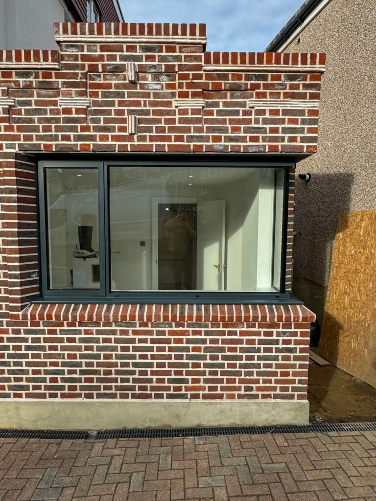 outside view of oriel and frameless box window in brickwork opening